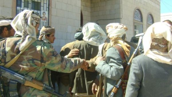Armed Yemeni tribesmen lead a blindfolded abductee to an unidentified place. (Photo PressTV)