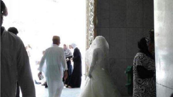عروس ترتدي فستان الزفاف تحاول الدخول للحرم المكي...فيديو