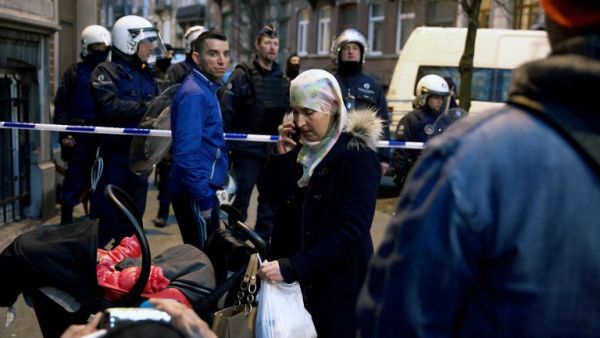 Inhabitants are stuck outside after the police set a security perimeter around Rue de la Carpe in Molenbeek-Saint-Jean in Brussels, on March 19, 2016. (AFP/Nicolas Maeterlinck)