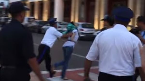 لقطة من الفيديو تظهر دفع رجل شرطة لفتاة مشاركة في الاحتجاج بقوة بالغة كادت تطيحها ارضا