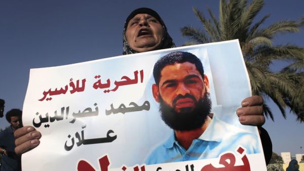 The mother of Muhammad Allan holds a sign calling for his release. (AFP/File)