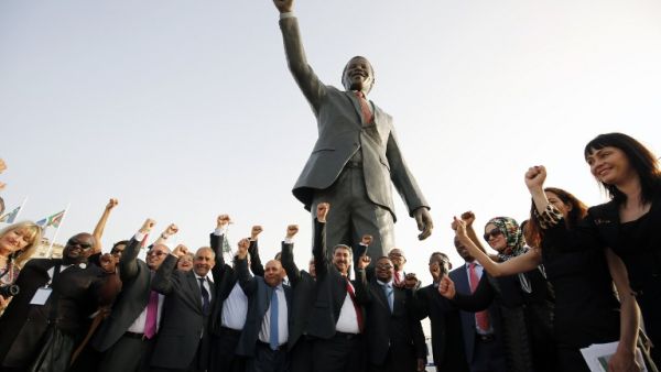 Palestinian and South African officials pose in front of a giant statue of Nelson Mandela during its inauguration ceremony in the West Bank city of Ramallah on April 26, 2016. (AFP/Abbas Momani)