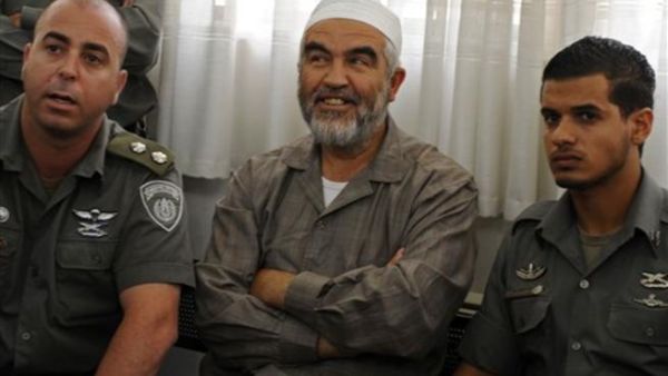 رئيس الحركة الاسلامية في اسرائيل الشيخ رائد صلاح يتوسط رجلي امن اسرائيليين