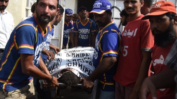 Pakistan rescuers shift the body of a passenger, who was killed in a train accident, to a mortuary in Karachi on November 3, 2016. (AFP/Rizwan Tabassum)