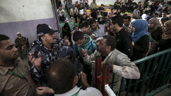 Palestinians residing in the Gaza Strip wait for a travel permit to cross into Egypt through the Rafah border crossing. (AFP/Said Khatib)