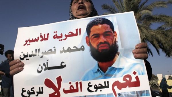 The mother of Mohammed Allaan, a Palestinian prisoner who was on a long-term hunger strike, holds a portrait of her son during a rally calling for his release on August 9, 2015. (AFP/ Ahmad Gharabli)