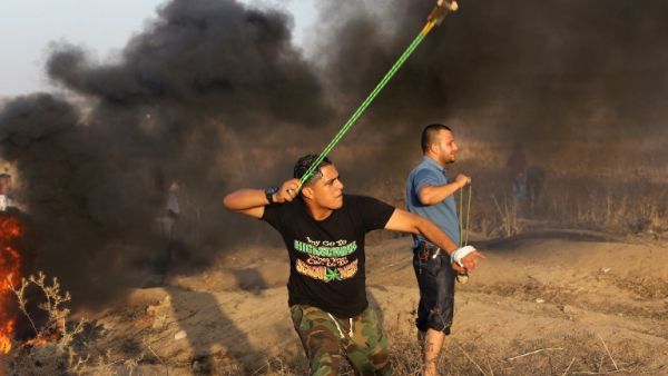 A Palestinian protester hurls a stone toward Israeli troops during clashes near a border fence between Israel and the Gaza Strip on Oct. 14, 2015 east of Bureij in central Gaza. (AFP/Mahmud Hams)