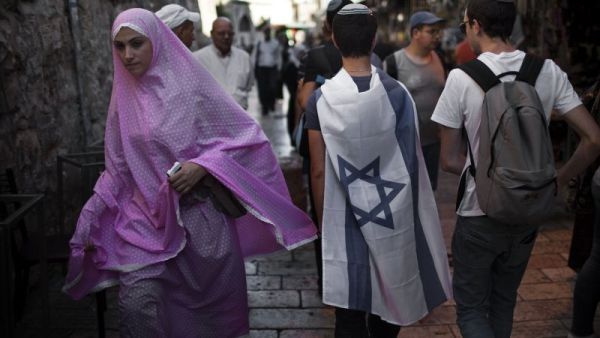 A Muslim Palestinian woman walks past Israelis in Jerusalem's old city.  (AFP/Menahem Kahana)