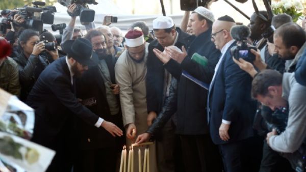 رجال دين مسلمون ويهود يضيئون الشموع امام مسرح باتاكلان
