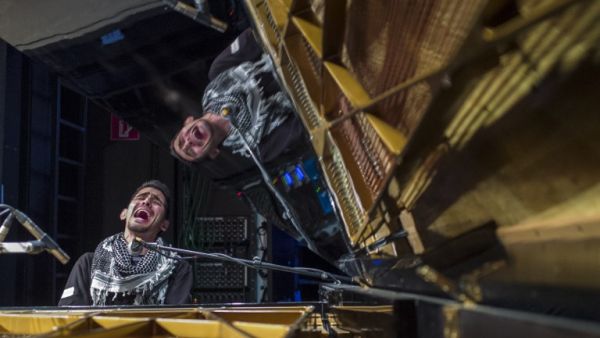 Palestinian-Syrian pianist Aeham Ahmad, known as the 'Pianist of Yarmouk,' performs at a Berlin concert hall on May 12, 2016.  Ahmad, who gained fame for performing outdoors in Damascus' Palestinian refugee camp Yarmouk, fled Syria in 2015 after Daesh militants torched his piano. (AFP/John McDougall)