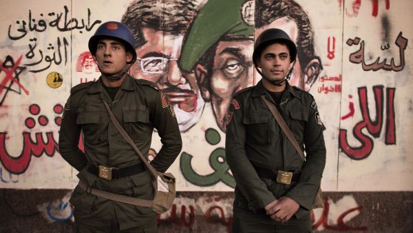 Egyptian security forces stand guard in front of satirical graffiti on the walls of the Presidential Palace in Cairo.  (AFP/File)