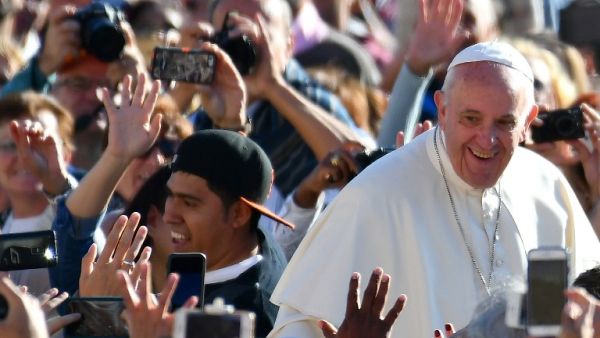 Pope Francis salutes the crowd as he arrives for his general audience in St Peter's square at the Vatican on October 5, 2016. (AFP/Vincenzo Pinto)