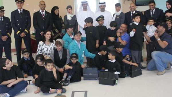 الأطفال والعاملين في مركز أبوظبي للتوحد مع فريق العمل في الاتحاد للطيران أثناء توزيح لوائح الآيباد