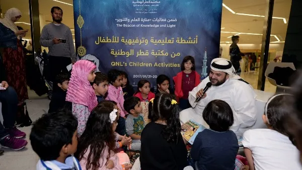أطفال يستمعون إلى قصة قدمتها مكتبة قطر الوطنية خلال مهرجان "منارة العلم والتنوير"