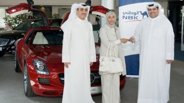 The winner Amina Al Zaidan receives the SLS keys from NBK General Manager, Consumer Banking Group Mazin Saad Al Nahedh and NBK Deputy General Manager, Consumer Banking Group Abdulla Al Najran Al Tuwaijri