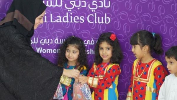 Eman Al Mansoori, Events Manager at Dubai Ladies Club gives children Hag Al Leilah goody bags