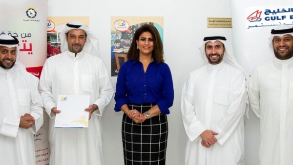 فريق بنك الخليج يتوسط فريق لجنة طالب العلم خلال تقديم منح الأيتام الدراسية بمناسبة اليوم العالمي لمحو الأمية.
