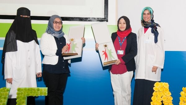 Dr. Manal Zaidan poses in a group photo with staff members during the celebration