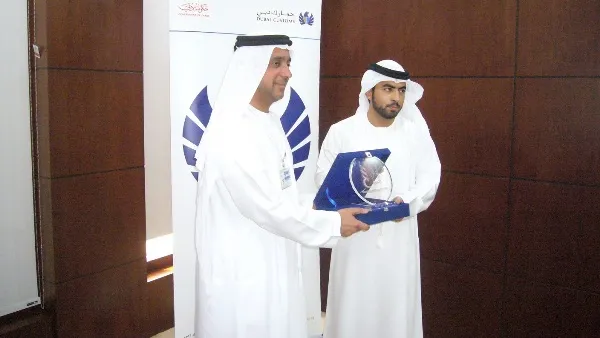 أحمد عبدالله بن لاحج يتسلم درع تذكاري من  راشد الفلاسي مدير المشاريع الخيرية بجمعية دبي الخيرية