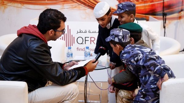 A group of young boys send a message to Qatar on National Day at the QF Radio booth at Qatar Foundation for Education, Science and Community Development’s (QF) Darb El-Saai tent.