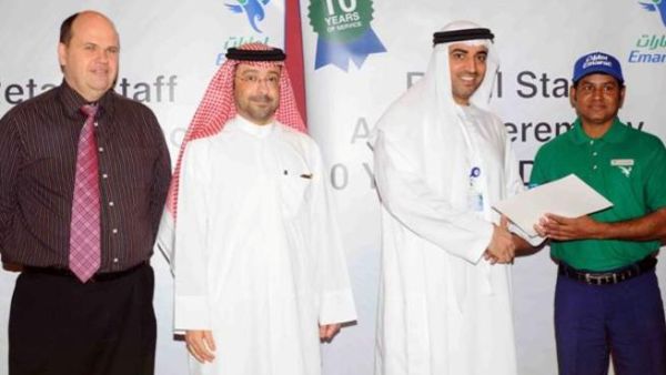 Dr. Rahma honors a staff member in the presence of Abdulla Al Noman, and Darren Smith