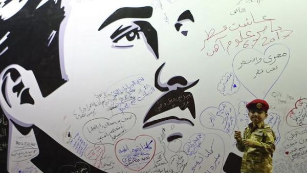 Qataris write on a wall bearing a portrait of Sheikh Tamim bin Hamad Al-Thani that has become a symbol of resistance during the Gulf diplomatic crisis. (Karim Jaafar/ AFP)