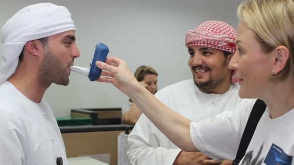 موظفا الشركة محمد حسين وصالح الزيتاوي أثناء قيام الممرضة ناتالي أدزهافي باجراء اختبار فحص أول أكسيد الكربون لهما في المقر الرئيسي للاتحاد للطيران في إطار الحملة التي تنظمها الشركة لموظفيها لمكافحة التدخين