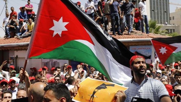Jordanian protesters wave national flags and shout slogans during an anti-austerity rally, on June 6, 2018, in front of the Labor Union offices in Amman. (AFP)