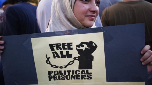 A woman holds up a sign at a demonstration in Cairo demanding freedom for all political prisoners in July 2012. (AFP/Gianluigi Guerci)