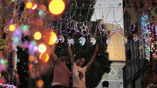 Men adorn Jerusalem's streets with Ramadan lights near the entrance of Al-Aqsa Mosque.  (AFP/File)