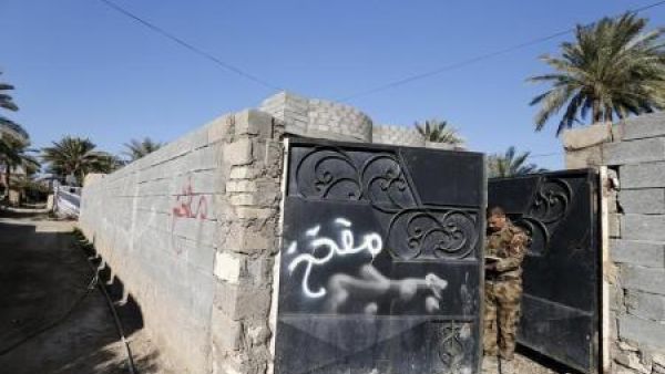 كتابة على جدران وبوابة منزل تحذر من الألغام في مدينة الرمادي 
