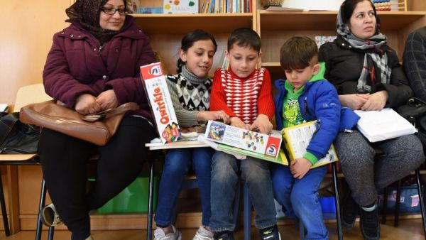 Refugee children and their parents from Afghanistan look at books and games in the refugee camp "Bayernkaserne" in Munich, southern Germany, on March 21, 2016. (AFP/Christof Stache) Refugee children and their parents from Afghanistan look at books and games in the refugee camp "Bayernkaserne" in Munich, southern Germany, on March 21, 2016. (AFP/Christof Stache)