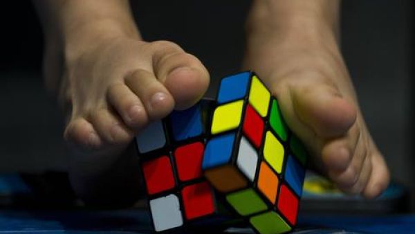 A young competitor tries to solve a Rubik's cube using the feet during the Rubik's Cube World Championship in Sao Paulo, Brazil. (AFP/ File Photo)