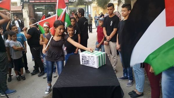 رفع الأطفال الذين تجمعوا أمام "نادي إبداع" قرب مدينة بيت لحم جنوبي الضفة الغربية لافتات داعمة للنادي الأسكتلندي،