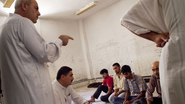 A Sharia lawyer speaks to prisoners at a temporary Islamic court set up in a rebel-controlled town outside Aleppo on September 5, 2012.  (AFP/Achilleas Zavallis)