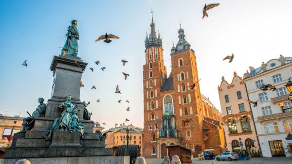 Old city center view with Adam Mickiewicz monument, St. Mary's Basilica and birds flying in Krakow (Shutterstock)