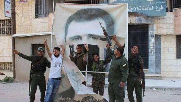 مقاتلون أكراد يمزقون صورة لبشار الأسد في القامشلي - عنب بلدي