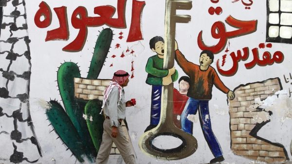 Palestinian man walks past a mural in the West Bank city of Jenin. The Arabic reads: "So that we don't forget the sacred right to return.(AFP/Saif Dahlah)