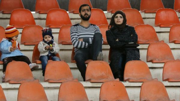 Fans attend a football game between Latakia's Hutteen and Hama's Taliya as part of the Syrian league at the Tishreen Sport City Stadium in Damascus. (AFP/File)