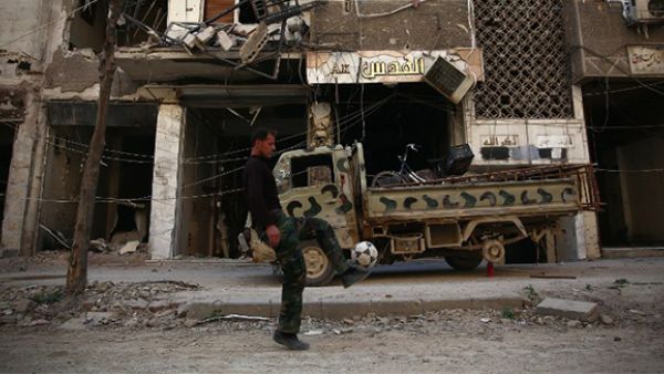 A rebel fighter plays football in a damaged street in the neighbourhood of Jobar, on the eastern outskirts of the Syrian capital Damascus. (AFP/File) 