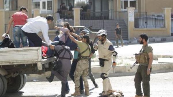 أفراد من "جيش الفتح" والدفاع المدني يساعدون مدنيين على الفرار من مدينة أريحا في شمال غرب سوريا بعد أن سيطر تحالف من قوات المعارضة السورية عليها يوم الخميس
