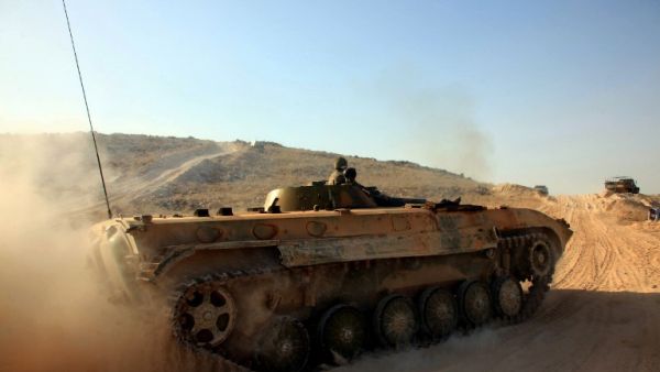 Syrian government forces drive a tank on a road during a military operation against Daesh in the villages of Zarour and Khanaser, in the Aleppo governorate, on February 26, 2016. (AFP/Georges Ourfalian)