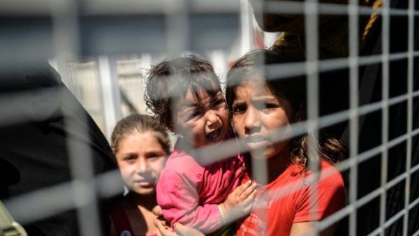 Syrian refugees wait at a Turkish border crossing to return home to the Syrian town of Tel Abyad, the scene of fierce fighting in June between Daesh and Kurdish forces.  (AFP/Bulent Kilic)