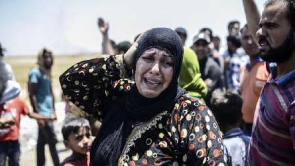 A Syrian woman cries at the Akcakale crossing on June 14, 2015, after an airstrike hit the eastern part of nearby Tal Abyad. (AFP/Bulent Kilic)