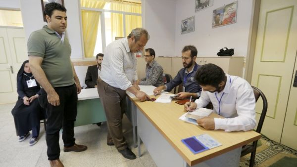 Iranian men arrive to cast their vote in the second round of parliamentary elections at a polling station in the town of Robat Karim, some 40 kms southwest of the capital Tehran, on April 29, 2016. (AFP/Atta Kenare)