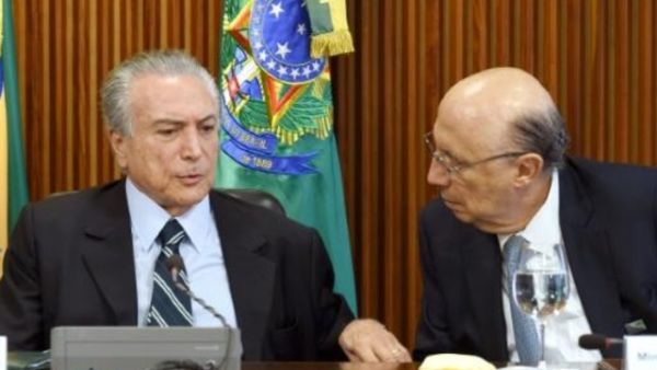 الرئيس المؤقت ميشال تامر (يسار) يتحدث الى وزير الاقتصاد انريكي ميريليس في اول اجتماع حكومي في قصر بلانالتو ببرازيليا
