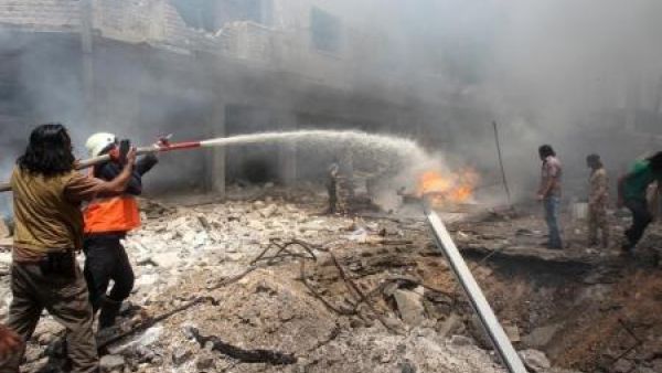 أشخاص يحاولون إطفاء حريق بعد ضربة جوية على إدلب يوم الاحد
