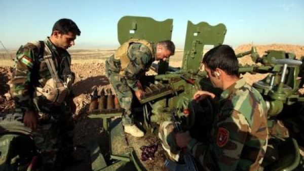 مقاتلون من قوات البشمركة الكردية يعيدون تلقيم سلاح خلال اشتباكات مع مقاتلي تنظيم الدولة الإسلامية في قرية شرقي الموصل
