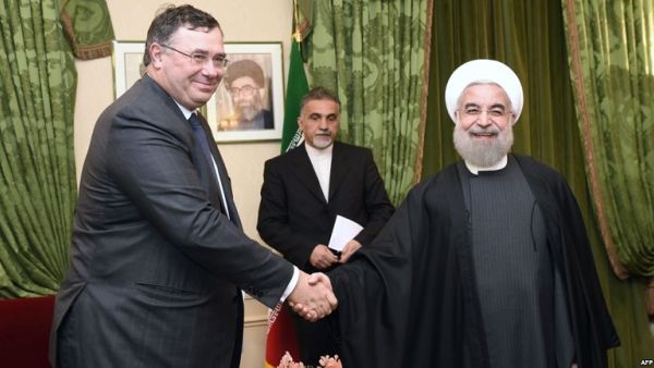 Total Chief Executive Officer Patrick Pouyanne (L) shakes hands with Iranian President Hassan Rouhani during a meeting in Paris on January 28, 2016. (Eric Fefferberg/ AFP)
