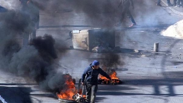 Tunisian demonstrators block the road with burning tires in the central city of Kasserine during protests, on 21 January, 2016, triggered by the death of an unemployed man. (AFP/ Mohamed Khalil)